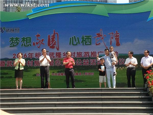 “村長”李銳為“愛心小天使”代表頒發徽章 李瓊/攝